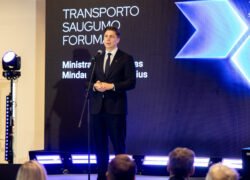 Vyras kostiumu kalba prie mikrofono transporto saugumo forume