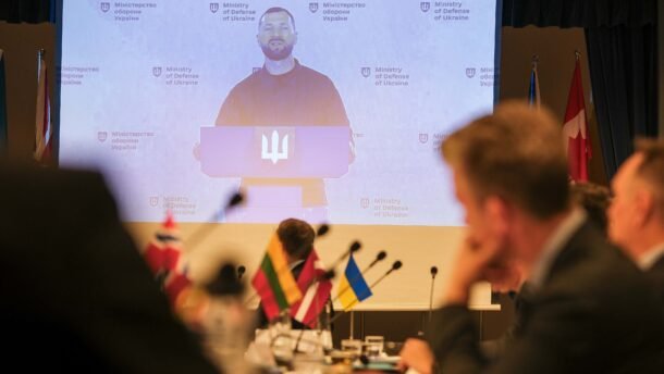 Konferencijos dalyviai stebi Ukrainos atstovo pranešimą dideliame ekrane