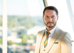 Verslo vyras su kostiumu stovi šviesiame biure