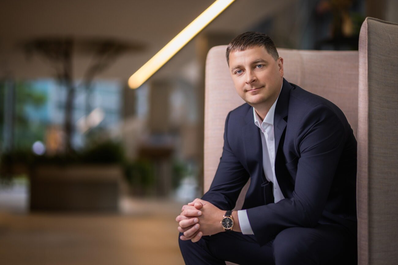 Verslo atstovas sėdi biuro krėsle modernioje darbo aplinkoje