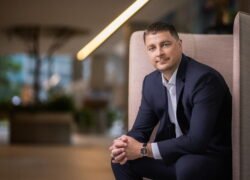 Verslo atstovas sėdi biuro krėsle modernioje darbo aplinkoje