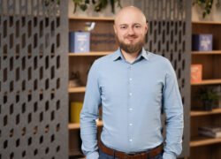Besidriekiantis vyras šviesiais marškiniais moderniame biuro interjere
