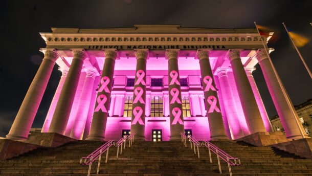 Vilniaus nacionalinė biblioteka naktį apšviesta rožine šviesa ir papuošta rožiniais kaspinais