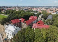 Iš paukščio skrydžio matomi raudonais stogais dengti pastatai ir Vilniaus panorama