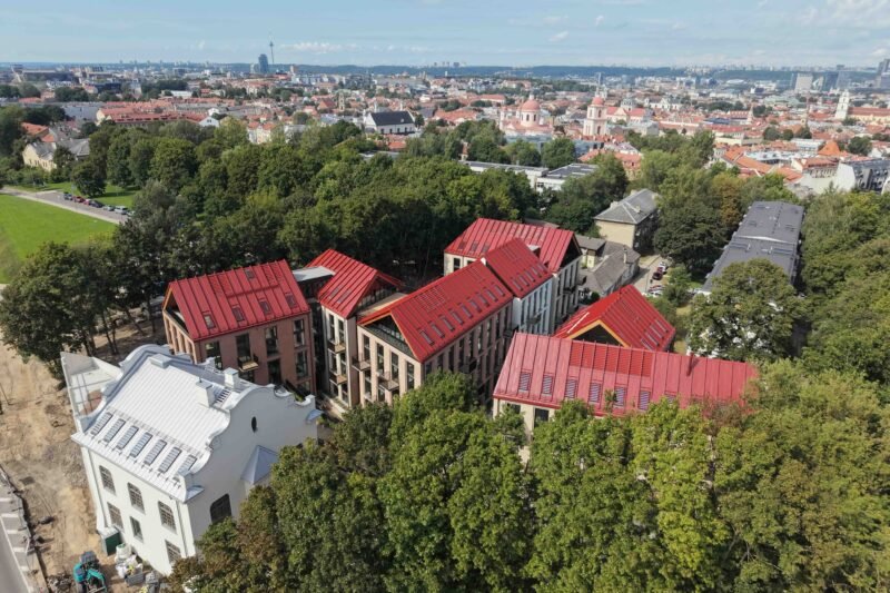 Iš paukščio skrydžio matomi raudonais stogais dengti pastatai ir Vilniaus panorama