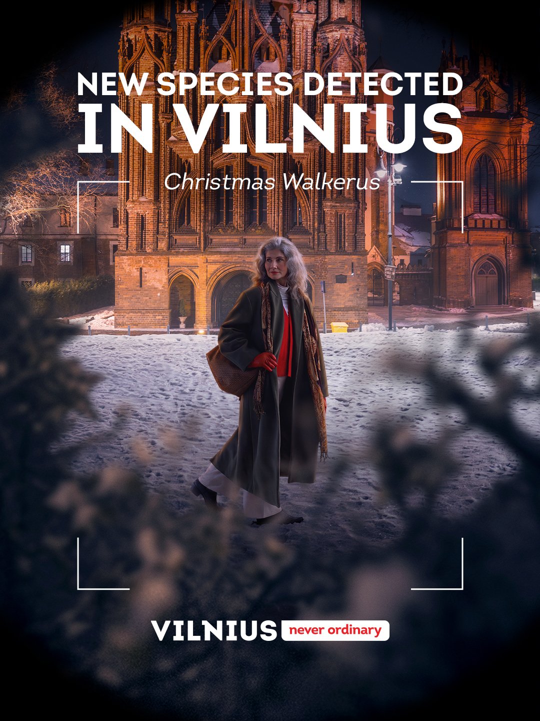 Žmogus su ilgu tamsiu apsiaustu snieguotame Vilniaus senamiestyje