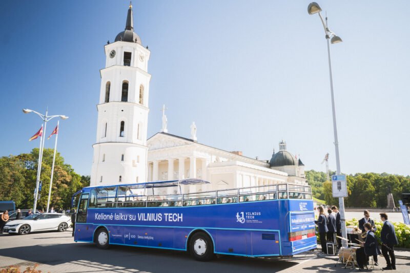 Mėlynas VILNIUS TECH autobusas prie Vilniaus katedros saulėtą dieną