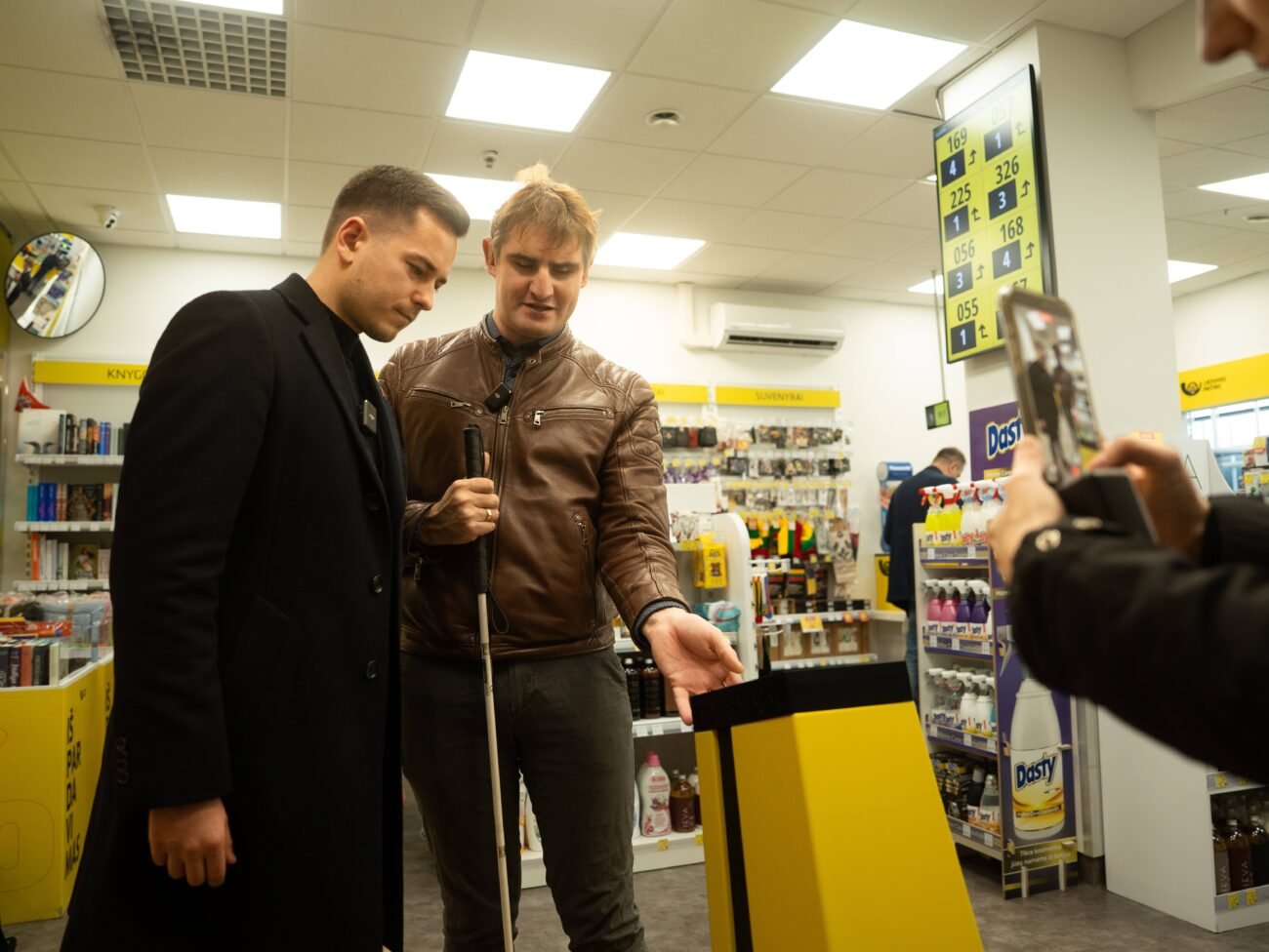Du vyrai parduotuvėje, vienas jų naudojasi baltąja lazdele