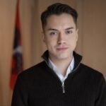 Jauno vyro portretas su keliomis vėliavomis fone