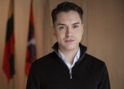 Jauno vyro portretas su keliomis vėliavomis fone