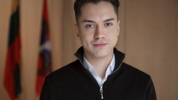 Jauno vyro portretas su keliomis vėliavomis fone