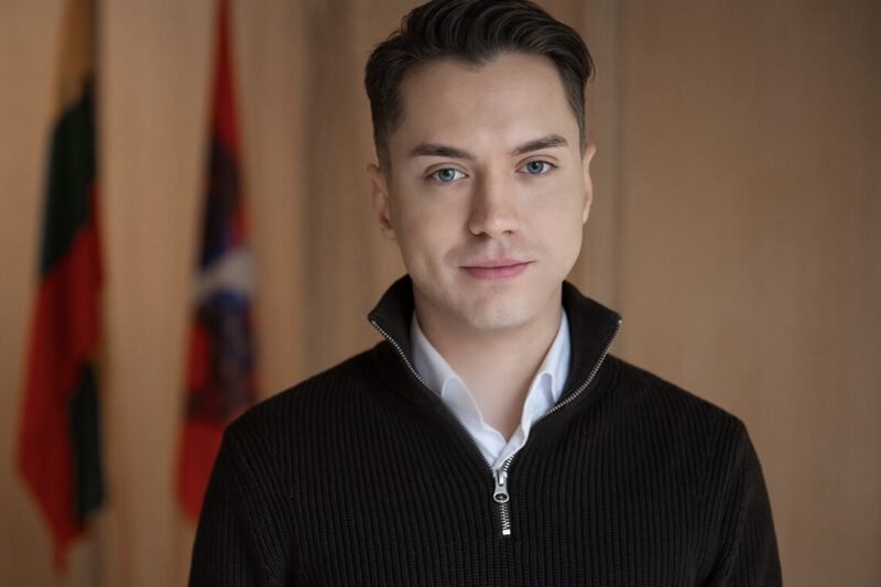 Jauno vyro portretas su keliomis vėliavomis fone